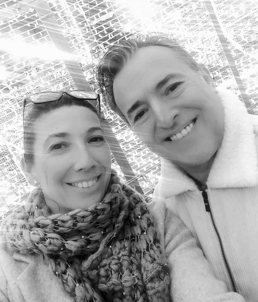 Pareja sonriendo al tomarse una selfie en un lugar iluminado.